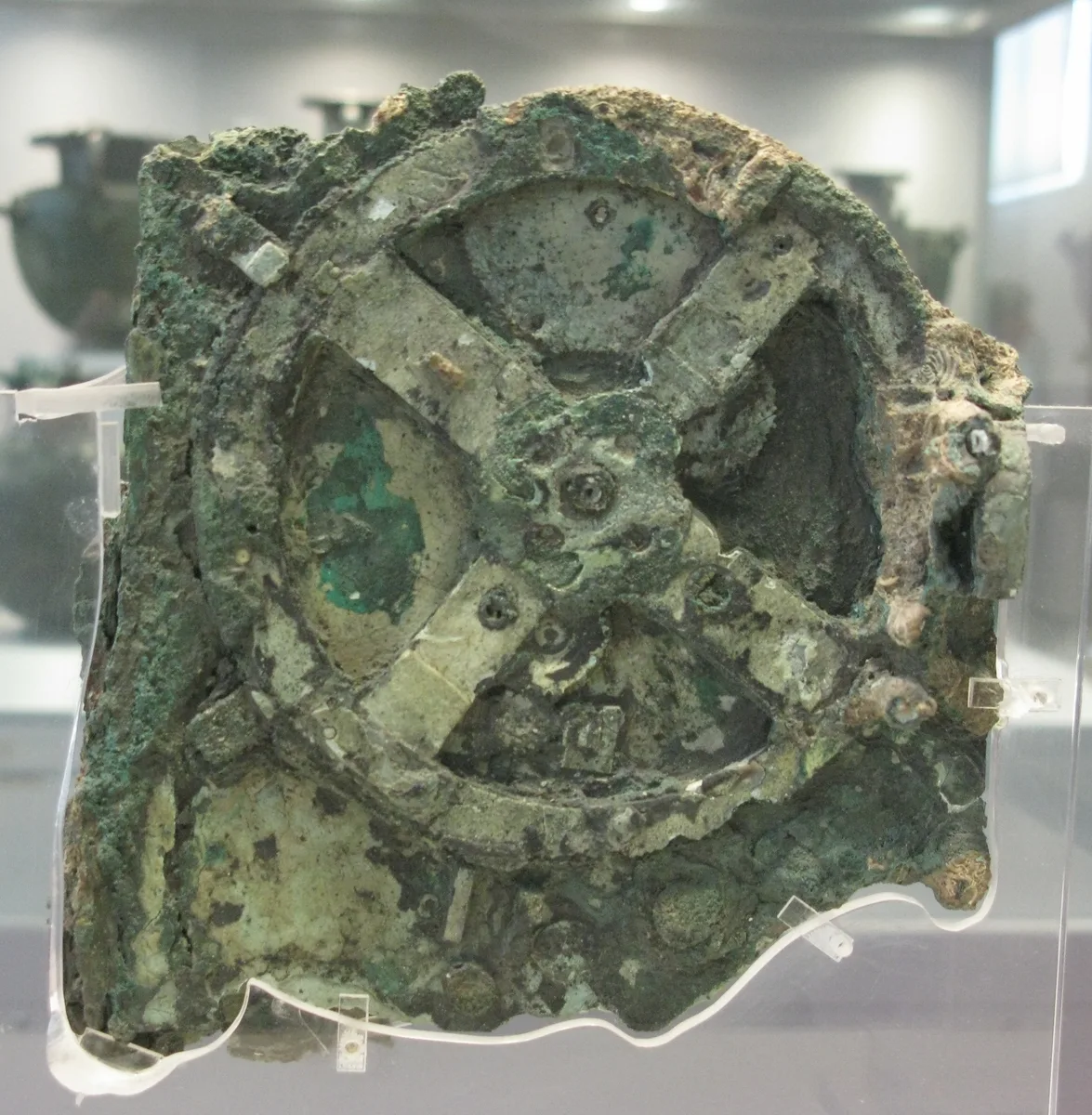 Fragmente des Mechanismus von Antikythera im Nationalmuseum Athen — korrodierte Bronzestücke hinter Glas