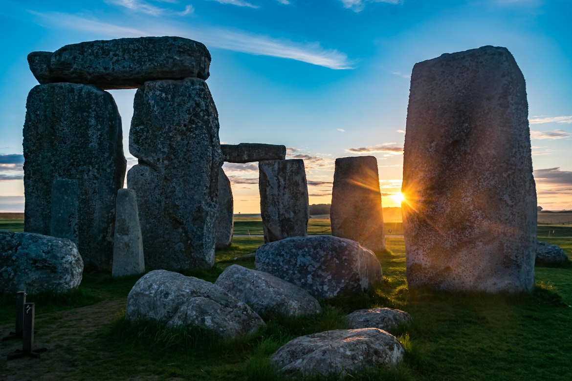Die Sonne scheint bei Sonnenuntergang durch die Lücken zwischen den Sarsen-Steinen von Stonehenge